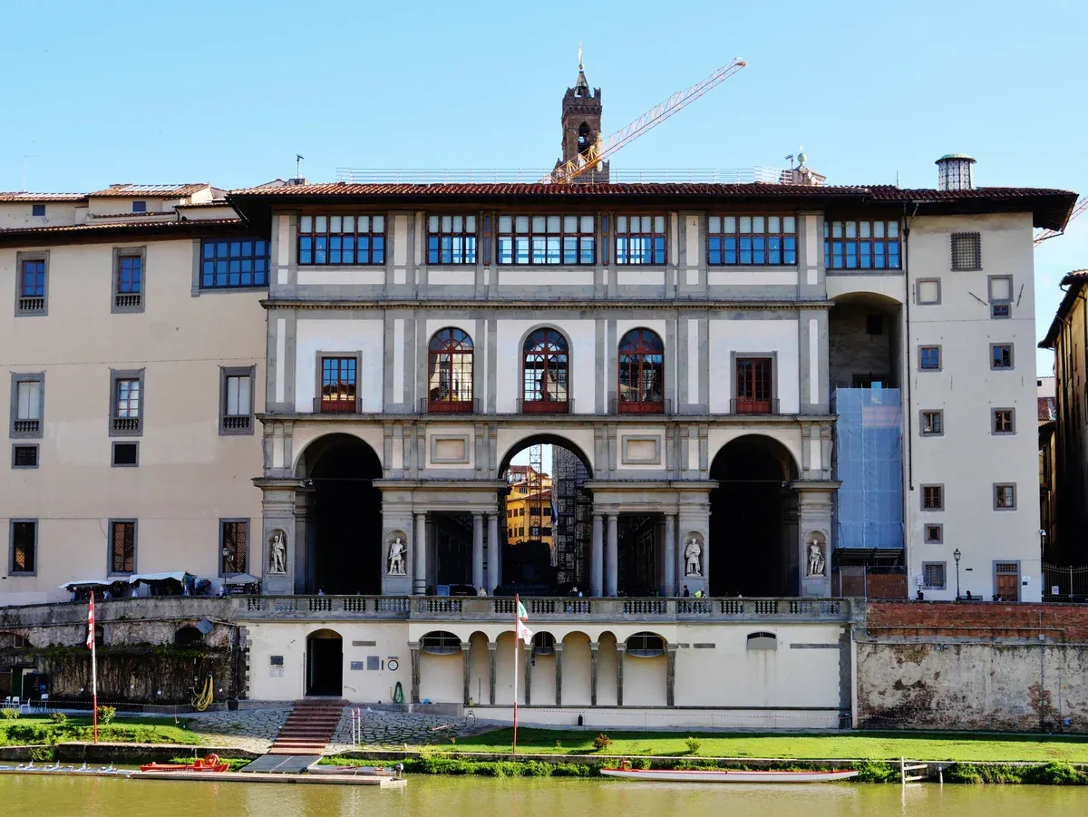 The Uffizi Gallery seen from across the Arno with the Vasari Corridor running along its riverside, closed on Mondays to tours from Rome to Florence